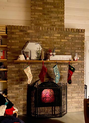 Masonry heater fireplace built in Alberta, Canada with Christmas stockings.